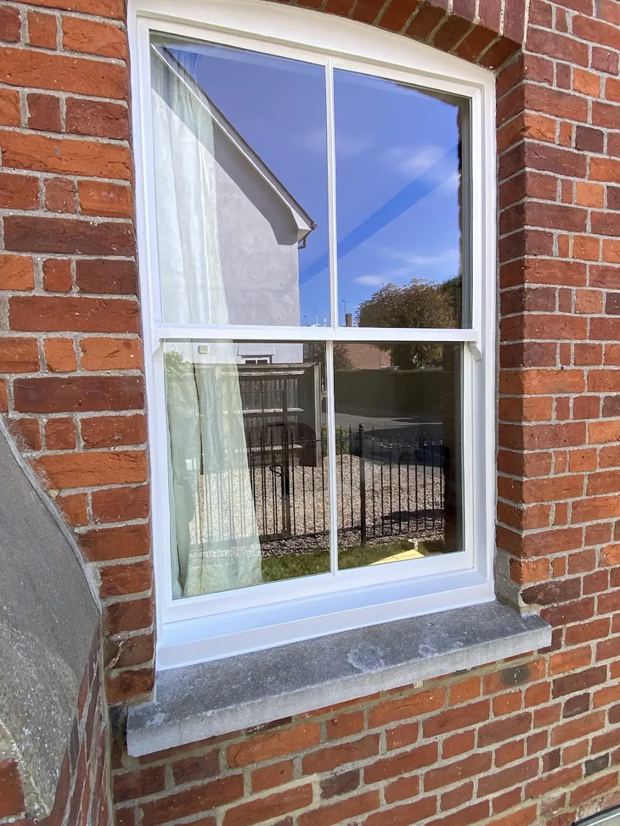 A restored timber sash window fitted with vacuum insulated glazing in a red-brick period house